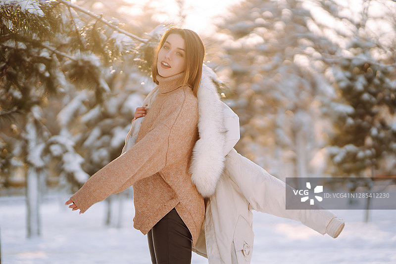 在白雪皑皑的公园里，年轻美丽的女子肖像图片素材