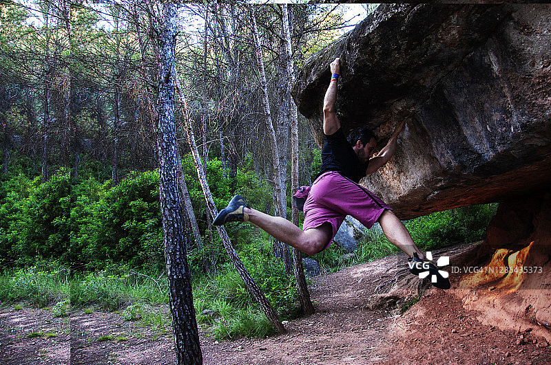 攀岩者在岩石上飞跃以到达目的地图片素材