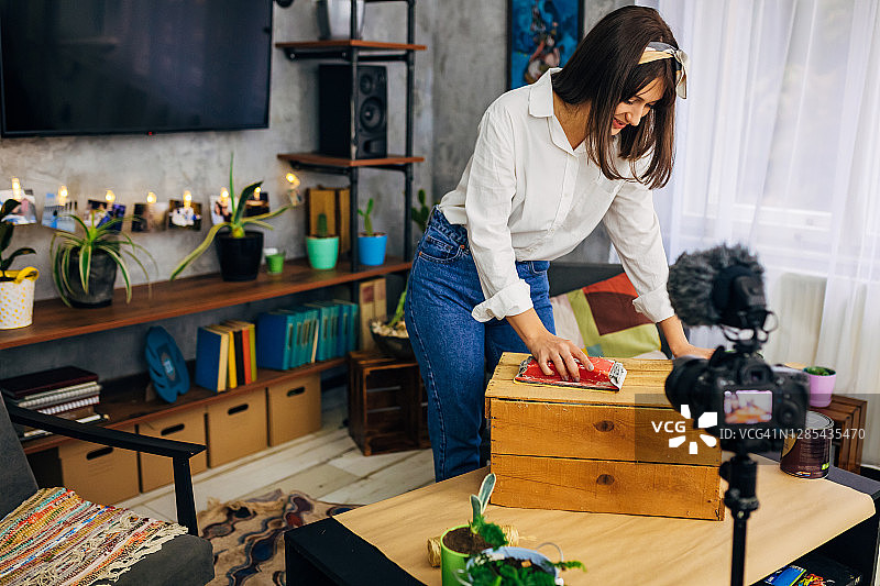 迷人的女性网红正在录制关于如何装饰家居的简易DIY教程图片素材
