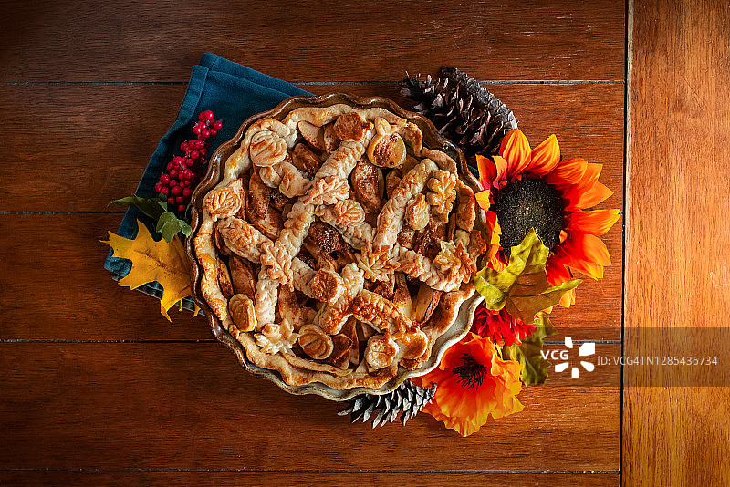 厨房桌子上装饰有秋季时令道具的苹果派图片素材