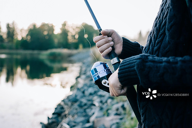 年轻男孩在日落时分钓鱼图片素材