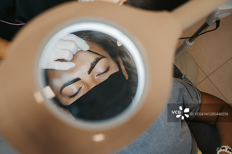 专业化妆师为顾客画眉毛图片素材