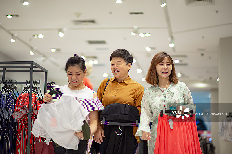 三位中国台湾女性朋友在购物中心服装店购物图片素材