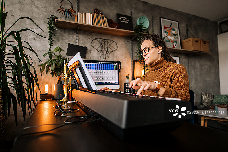 年轻钢琴家在家中练习钢琴曲图片素材