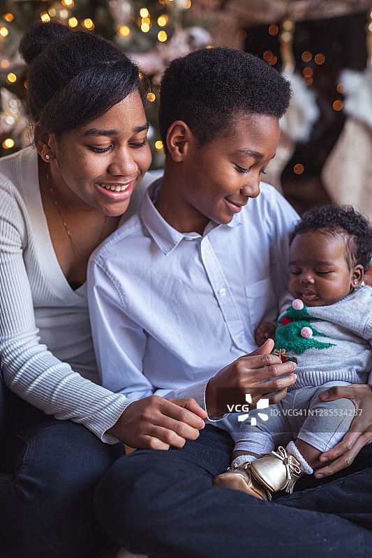 圣诞节那天，兄弟姐妹喜欢他们的新妹妹图片素材