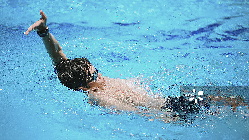 亚洲游泳运动员在游泳池里仰泳图片素材