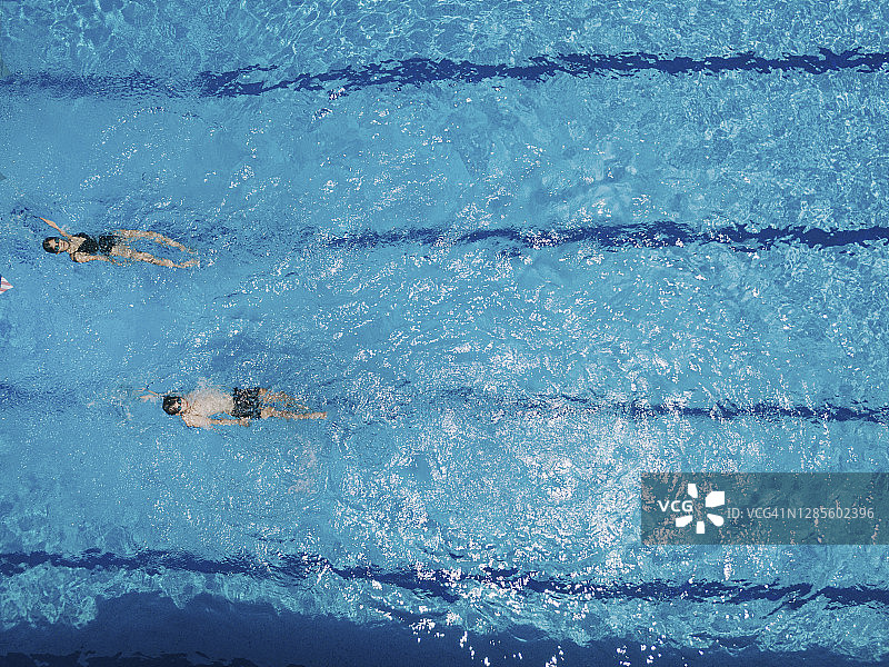 无人机直接俯视在游泳池游泳的亚洲华人游泳者图片素材