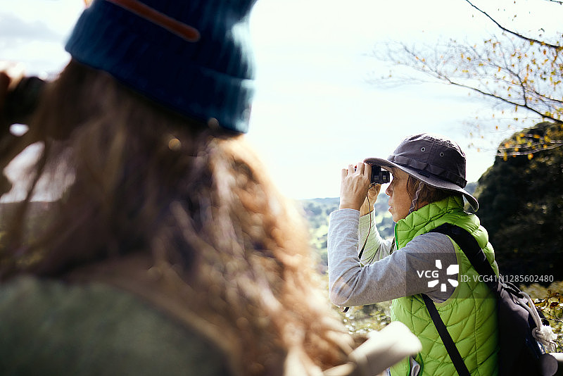 他们用双筒望远镜在山顶上欣赏风景图片素材