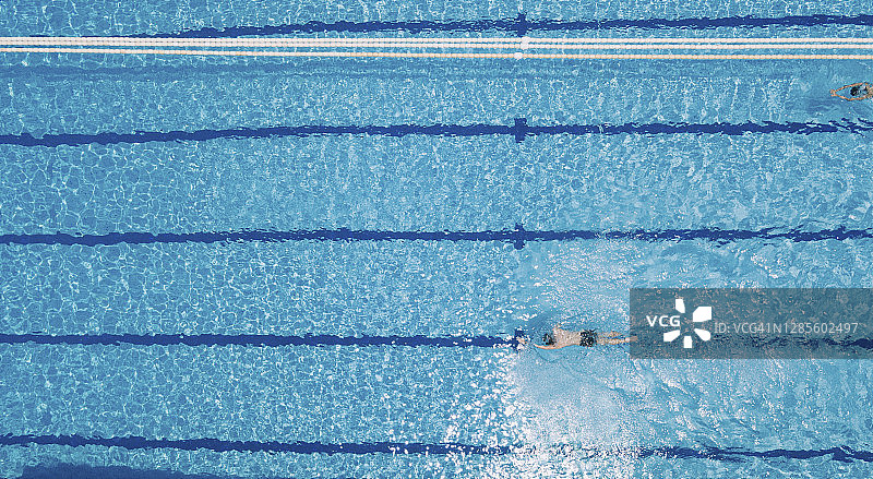 无人机直接俯视在游泳池游泳的亚洲华人游泳者图片素材