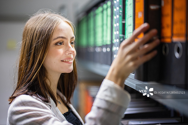 在公司财务档案中检查文件的女会计师图片素材