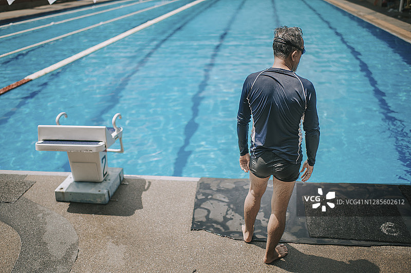 准备跳入泳池的亚洲老年男子图片素材