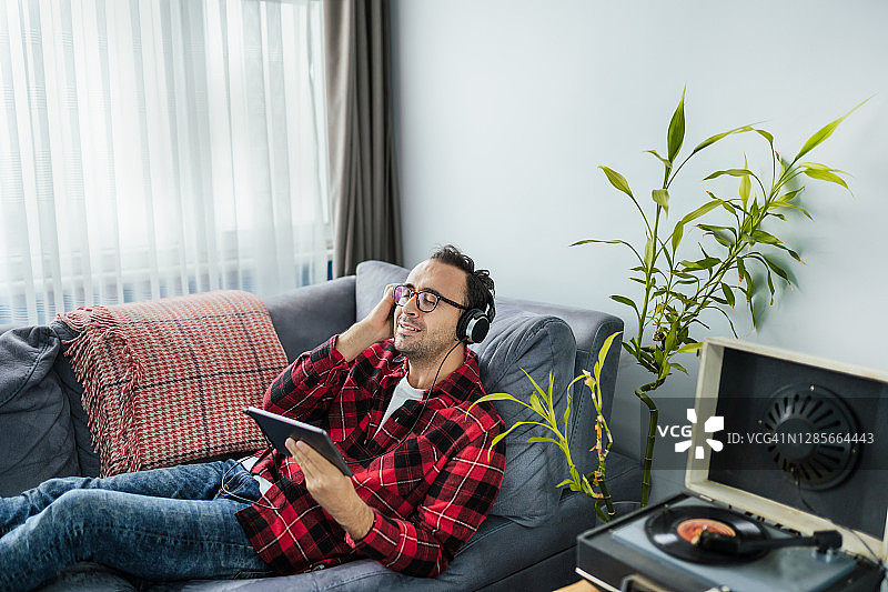 年轻男子在床上用平板电脑看电影图片素材