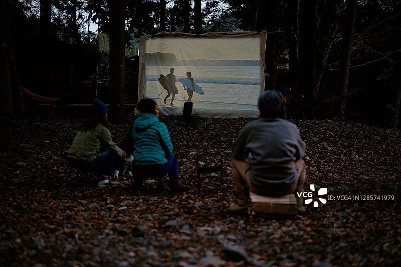 人们在木屋前观看露天电影图片素材