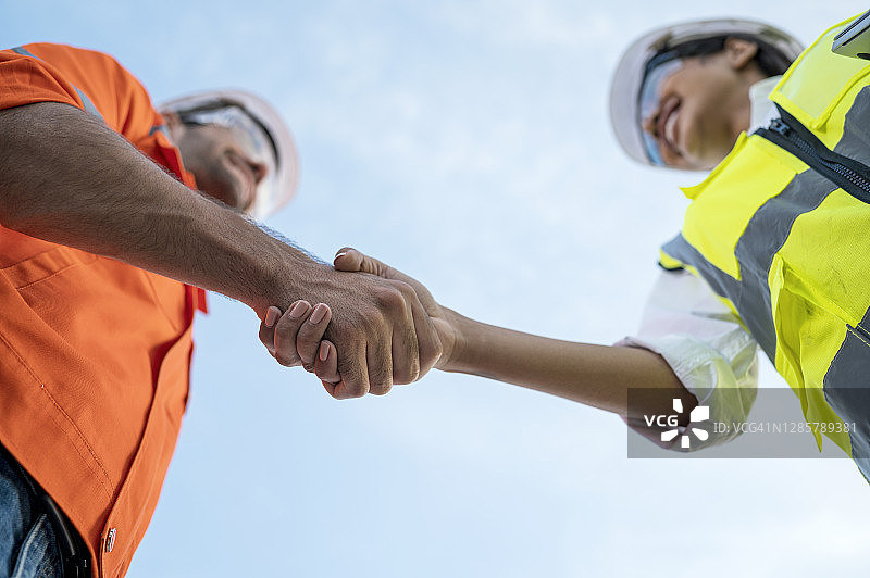 建筑工地经理与工程师互相问候仰视，团队合作图片素材