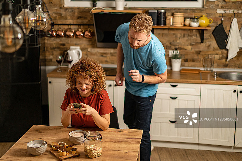 年轻男人查看女友的手机图片素材