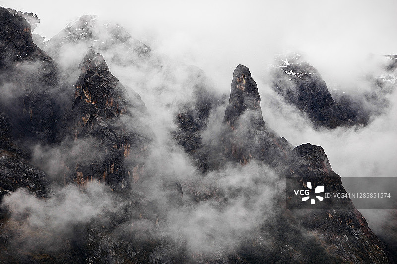秘鲁瓦拉斯圣克鲁斯步道上被云雾笼罩的锯齿状安第斯山峰图片素材