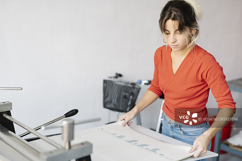 年轻女人准备凹版印刷机摄影图片素材