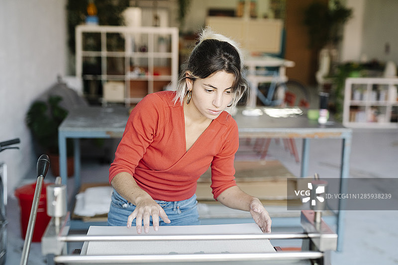 年轻女人准备凹版印刷机摄影图片素材