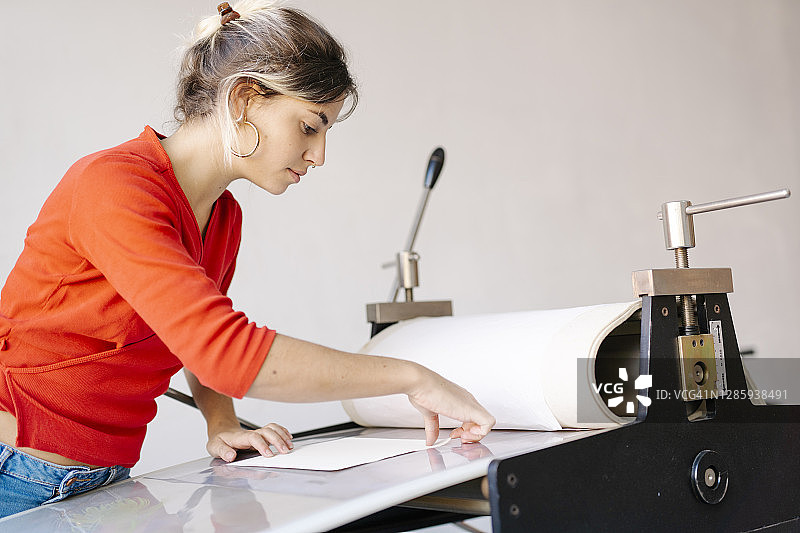 年轻女人在凹版印刷机上准备亚洲插图-库存照片图片素材