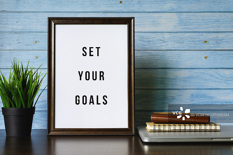 设定你的目标。工作桌上的木框和盆栽图片素材