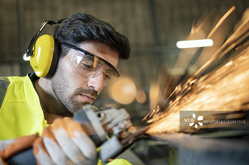 工人在车间使用圆锯打磨金属工件图片素材