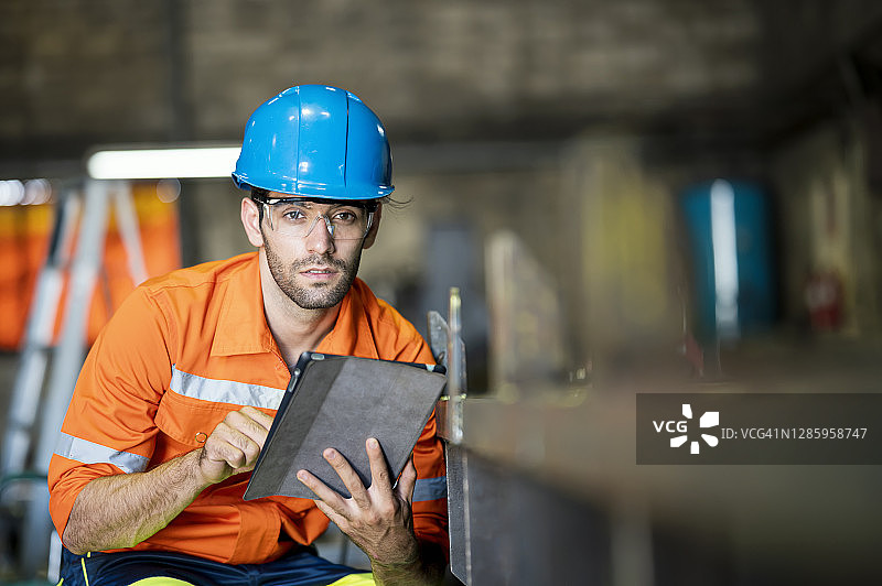 质检工程师在车间用触摸屏检查金属元件图片素材