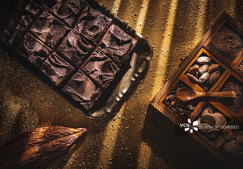 可可豆盒金色桌上的布朗尼巧克力蛋糕图片素材