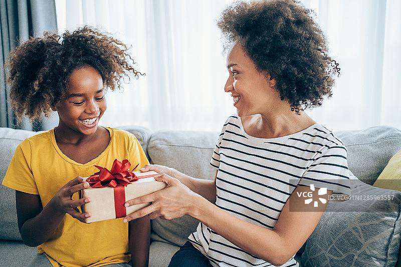 快乐的孩子收到妈妈的礼物。图片素材