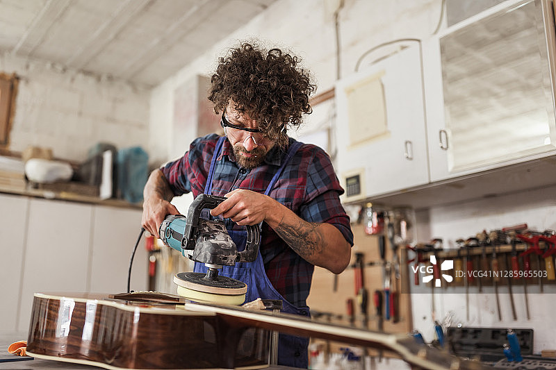 工人在他的工作室修理原声吉他图片素材