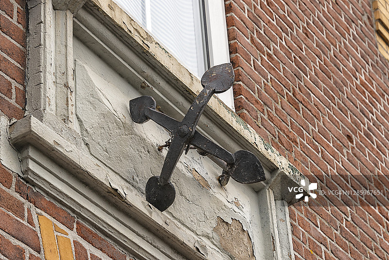 悬挂在石墙上的四爪钢锚图片素材