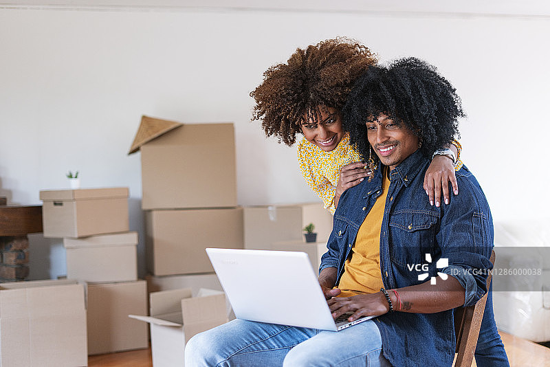 情侣在搬家途中坐在笔记本电脑前图片素材