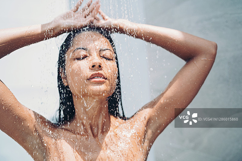 年轻女子闭着眼睛享受淋浴图片素材