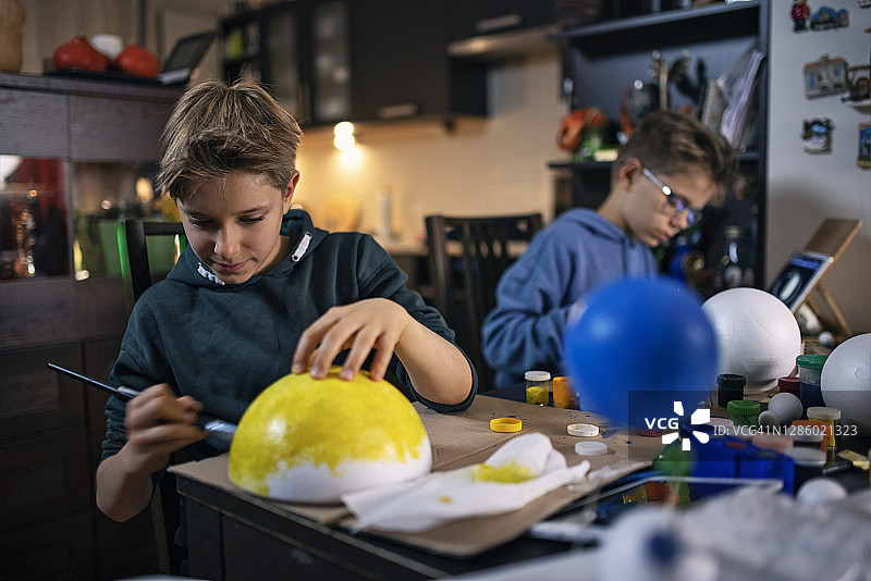 小男孩在家制作太阳系模型图片素材