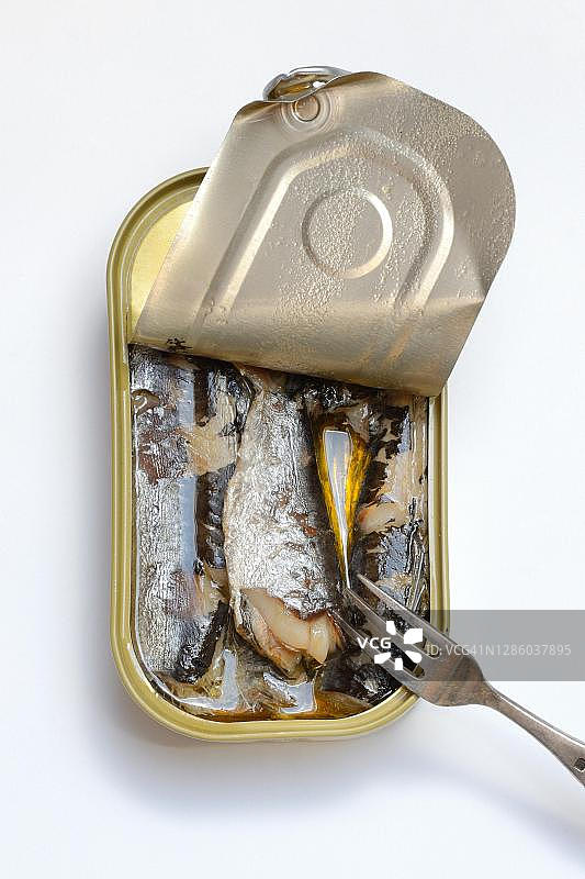 打开的沙丁鱼罐头和叉子，德国油浸沙丁鱼图片素材