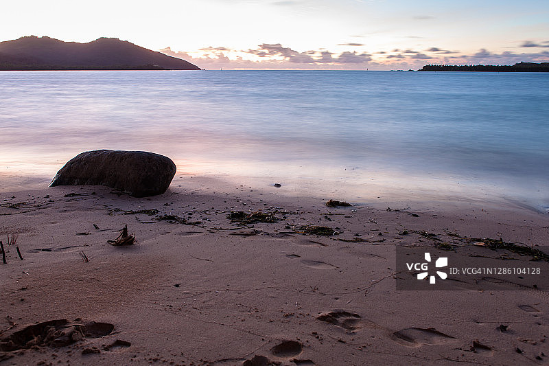 日落时分有巨石的热带海岛海滩图片素材