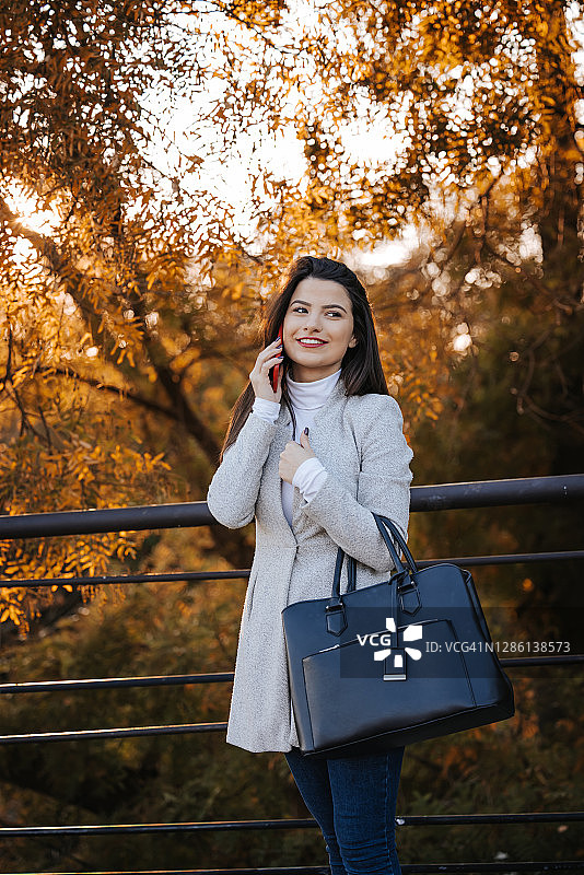 年轻女人在城市公园使用手机图片素材