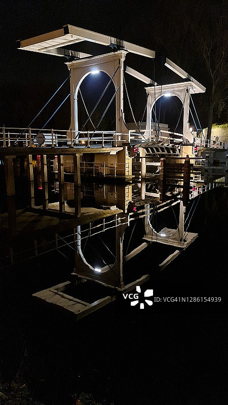 夜间河上照明桥梁的倒影图片素材