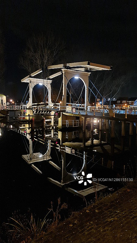 夜间河上照明桥梁的倒影图片素材