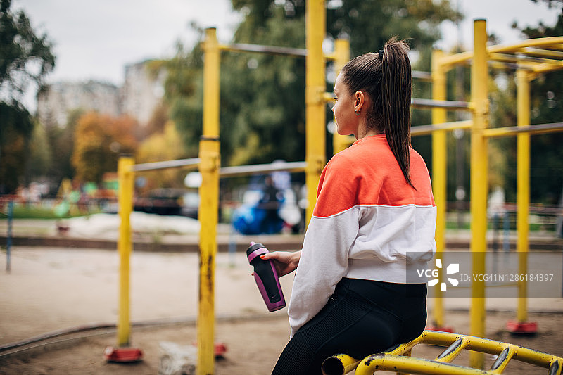 户外锻炼后休息的年轻女运动员图片素材