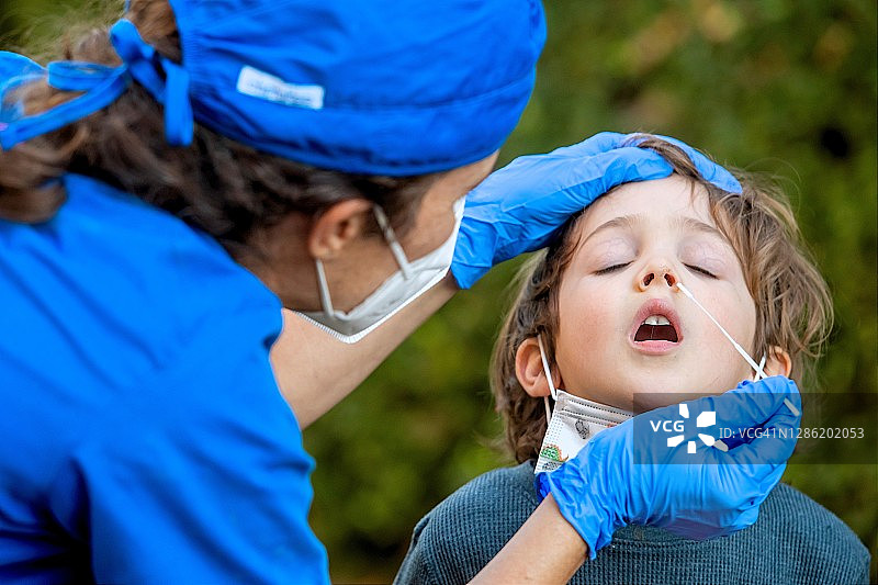 女护士在男孩返校前为他做新冠病毒检测图片素材