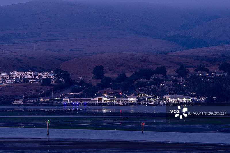 在加利福尼亚州博德加湾，眺望着海湾，远处有码头的夜景图片素材