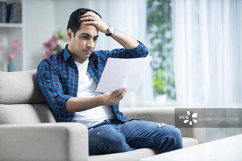 坐在家里沙发上的年轻男人图片素材