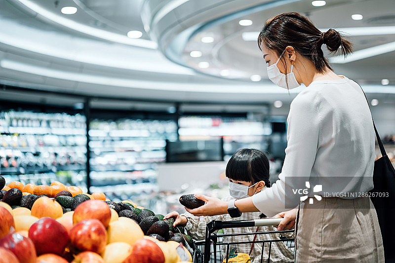 亚洲母女戴口罩在超市购买新鲜健康果蔬图片素材