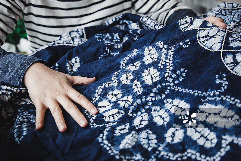 亚洲女性检查她的扎染作品图片素材