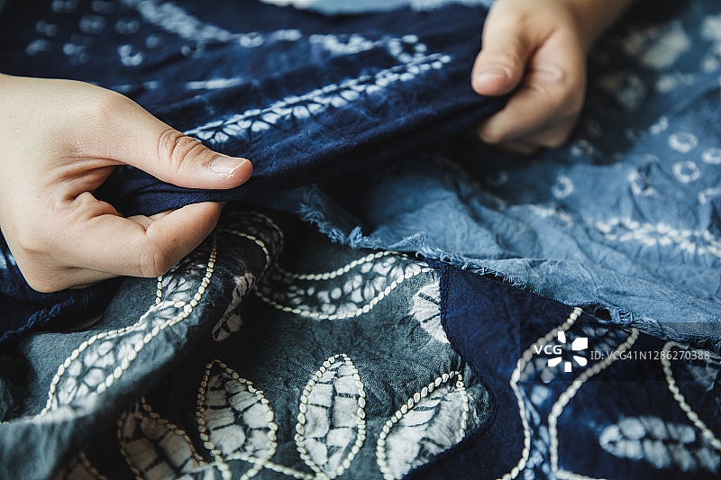 亚洲女性检查她的扎染作品图片素材