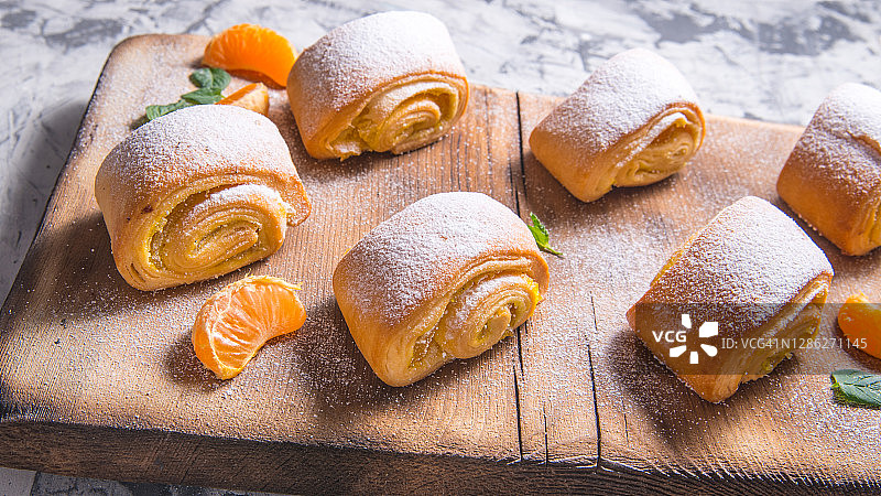 烘焙奥地利馅饼：木板上撒有薄荷叶、橘子、肉桂棒的卷饼，留有文字空间，侧视图图片素材