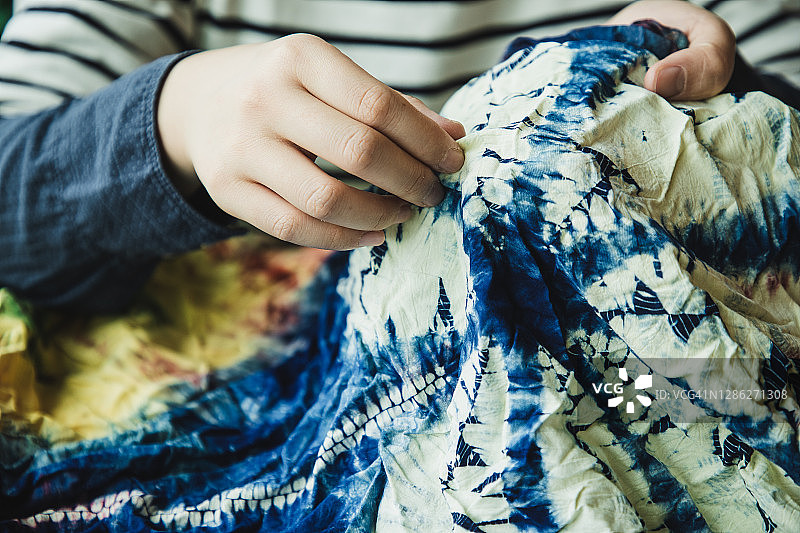 亚洲女性检查她的扎染作品图片素材