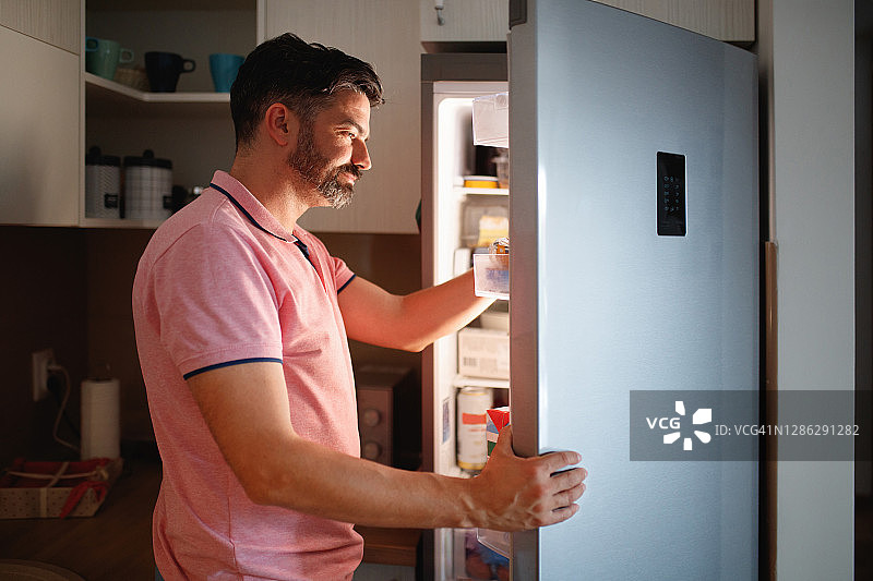 男人在冰箱里找食物图片素材