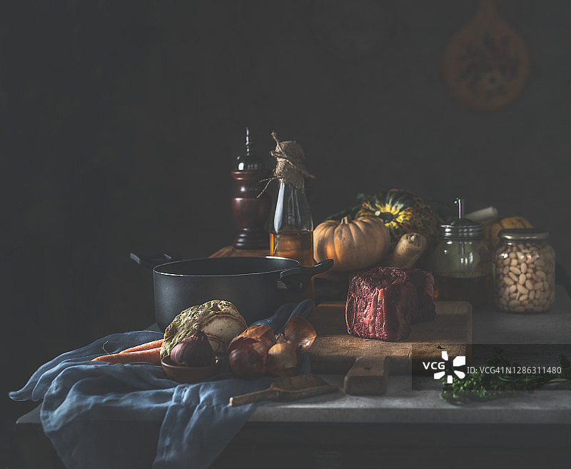 深色乡村厨房，黑色烹饪锅、油瓶和新鲜食材图片素材