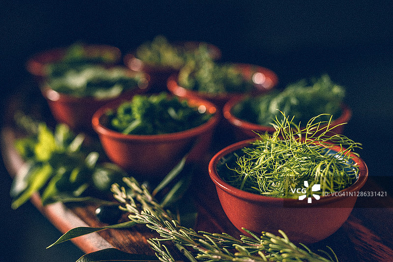 乡村木板上不同绿色香草的低调照片，焦点在茴香上图片素材